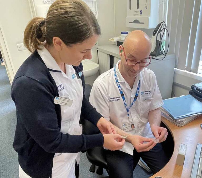 Audiologist With Hearing Loss Assists Patients Audiologist With Hearing Loss Assists Patients