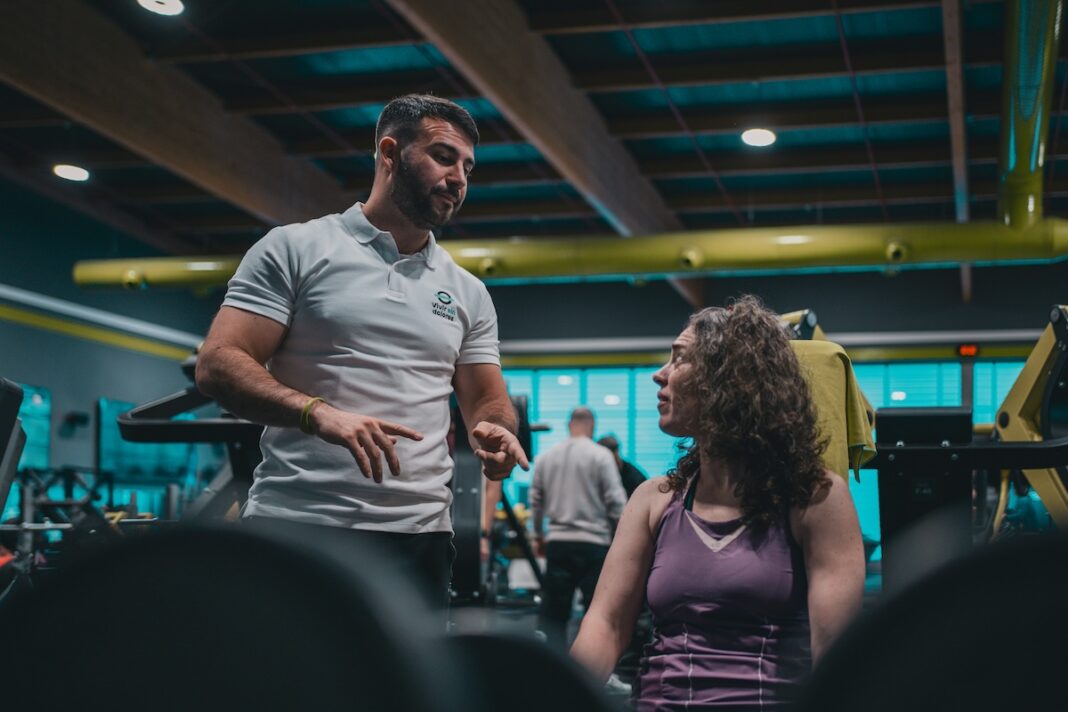 fitness instructor talking to someone in gym